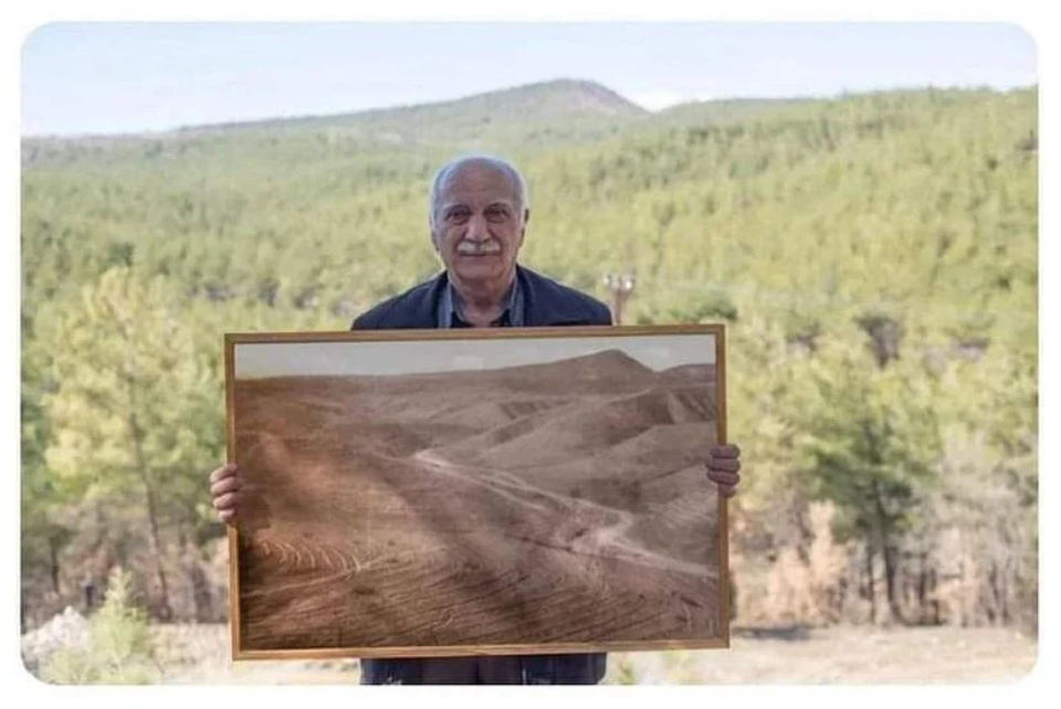 Man position with picture of forest he restored.