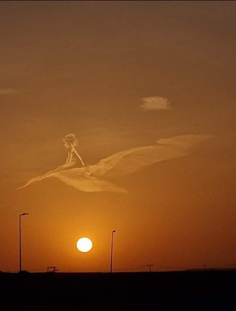 A picture taken yesterday at sunset of a cloud formed in the form of a child sitting on the back of a bird as if they were flying together in the sky.
