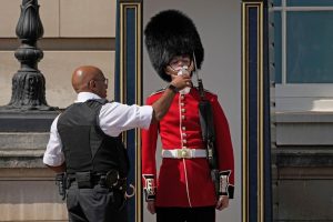 Police officer giving a Buckingham Palace Guard water amid the heatwave in the United Kingdom