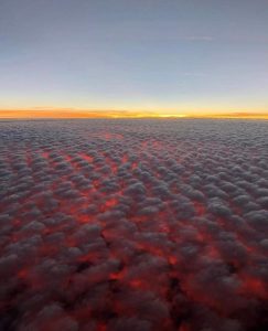 This is what a sunset looks like from above Altocumulus clouds at 30,000 ft in the air near O'ahu, Hawai'i.